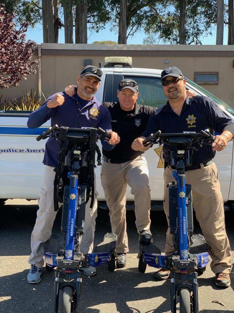 Three UCPD police officers stand with two Trikke Defenders
