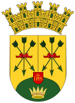 Coat of arms crowned gold shield with three green trees tied by red ribbons on a yellow field