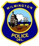 Wilmington DE Wilmington Police Department badge emblem: blue shield with gold border, 'Wilmington Police Del.' at top, central scene showing a courthouse tower, steam train, and river.