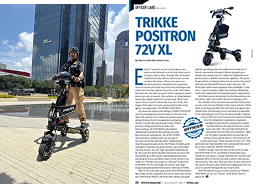 Group 1 1 | Trikke Professional Mobility Person riding a compact black electric mobility scooter outdoors next to modern glass buildings the right panel shows a product brochure for the Trikke Positron 72V XL with specs and features
