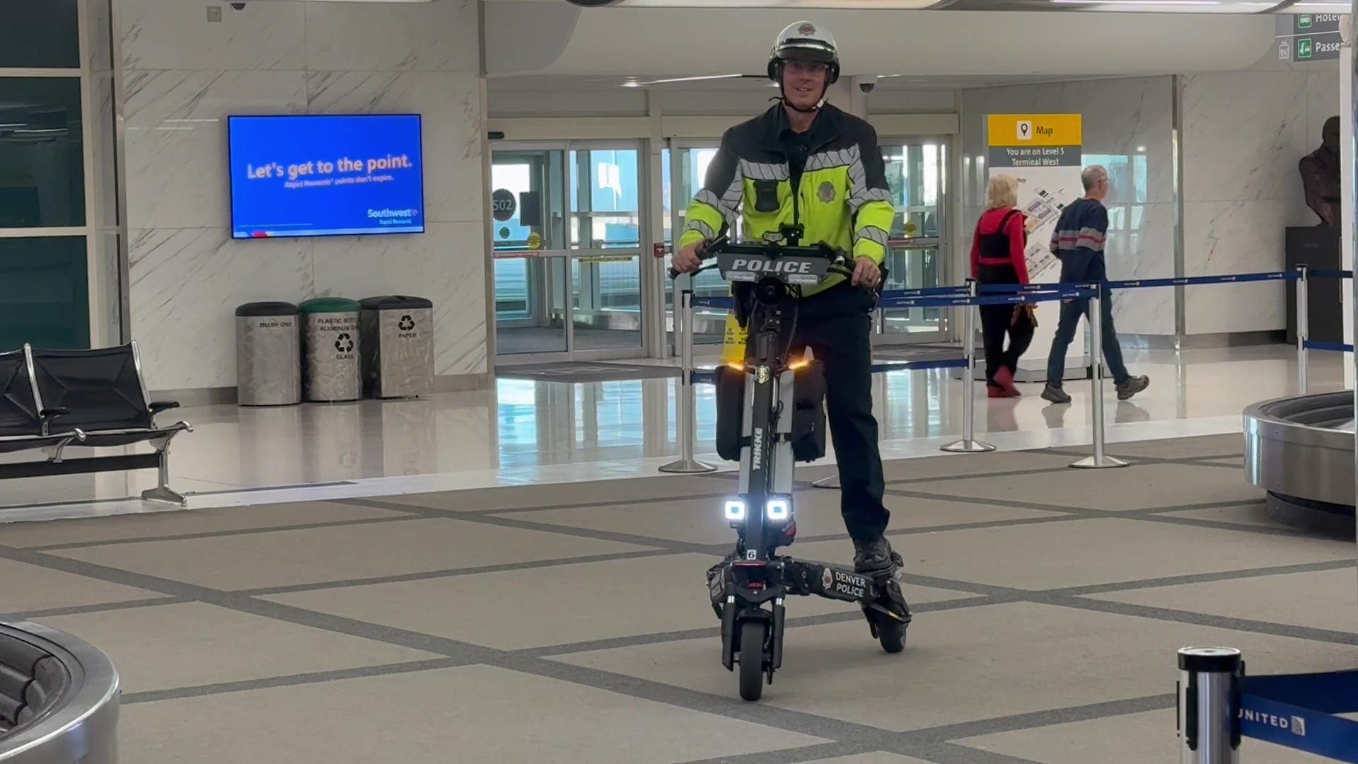 Denver Police | Trikke Professional Mobility Police officer in high visibility jacket rides a black electric patrol scooter in an airport terminal